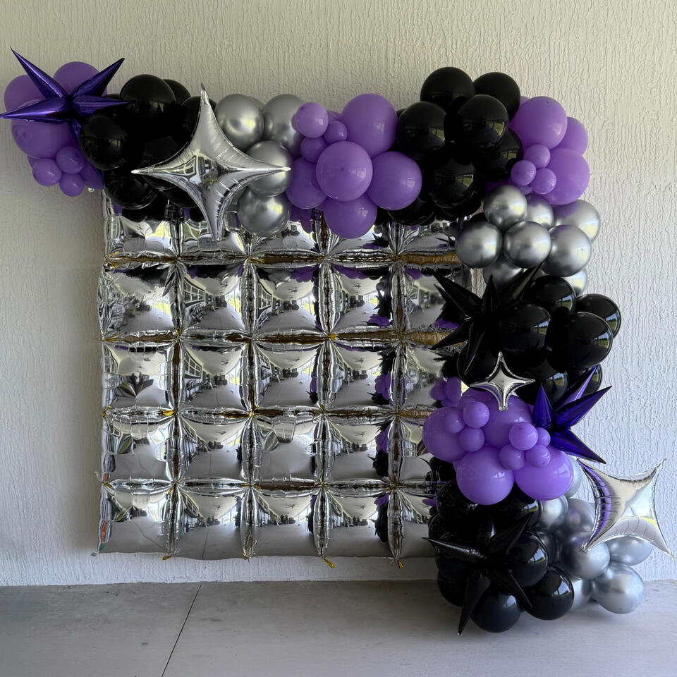 silver foil wall feature with an organic garland in purple, black, and silver