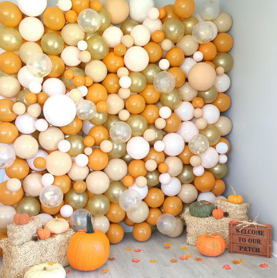 balloon wall with orange accents and pumpkin props