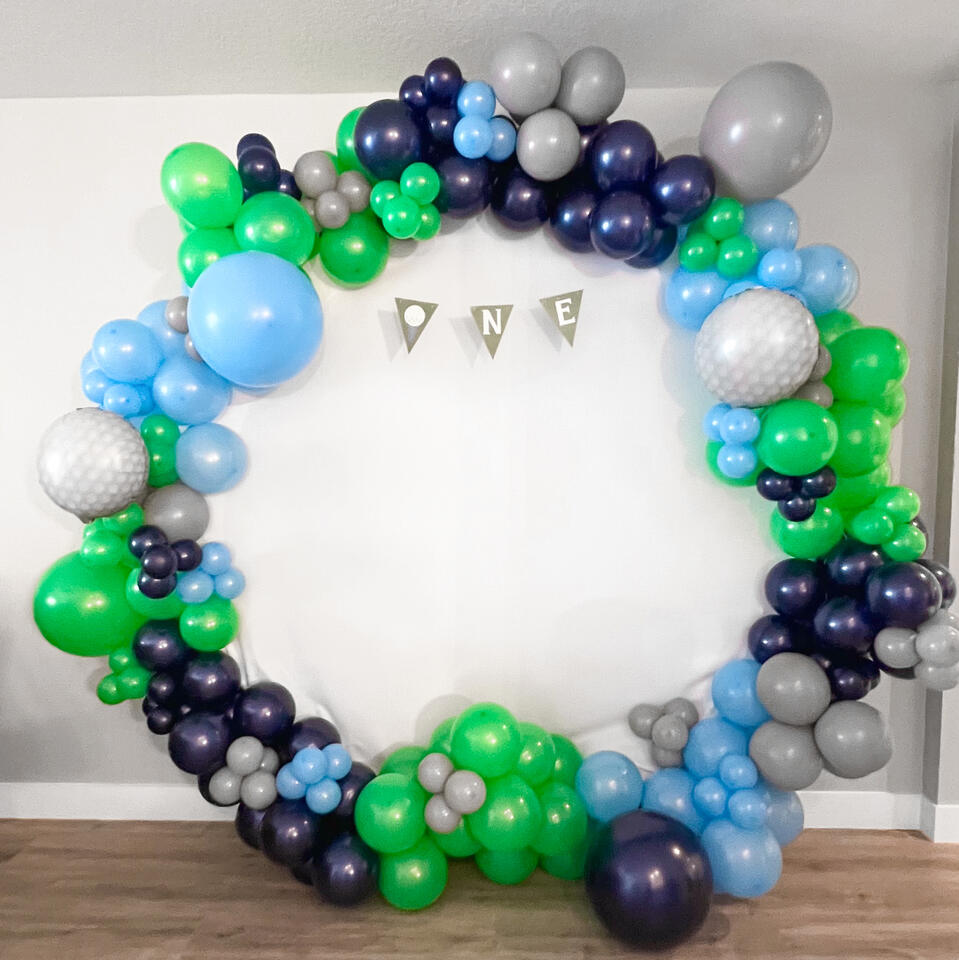 Hole in One Full Hoop golf themed balloon garland with a first birthday banner