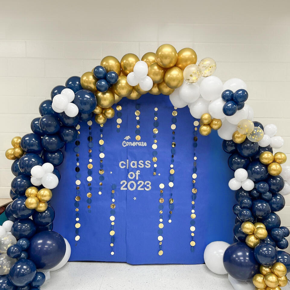 graduation themed balloon arch with paper backdrop