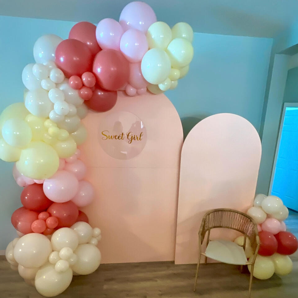 sweet girl themed baby shower set up with arches and organic balloon garland